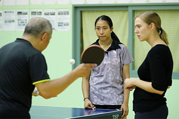 東京2020特別プログラム長期受入選手：サリー・イー （2018年7月6日～）卓球／フィジー／受入先：鎮西学院高校鎮西学院高校でコーチから指導を受けるサリー選手（写真：アフロスポーツ）