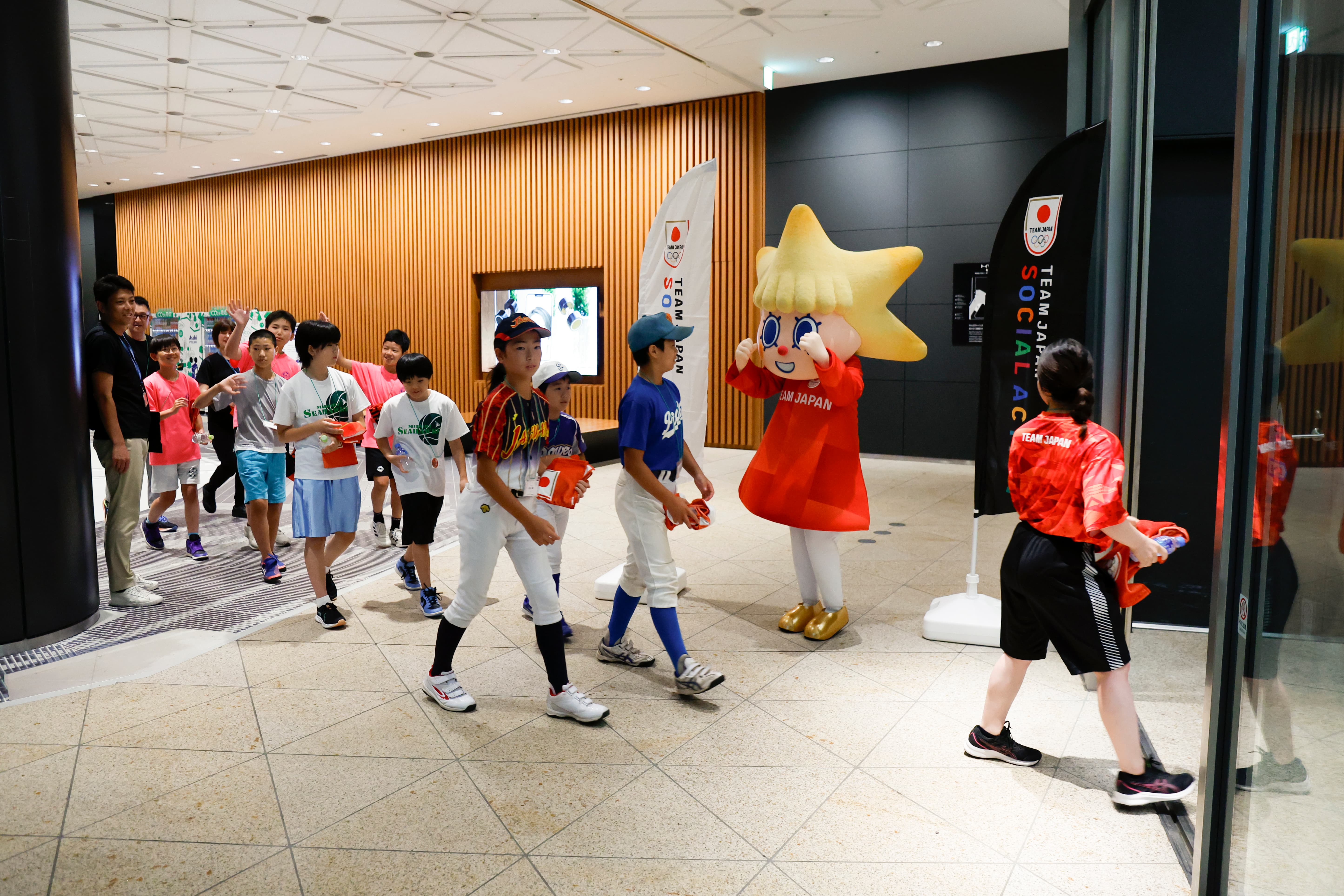 ソラカラちゃんに見送られて展望台に向かう小学生（写真：フォート・キシモト）