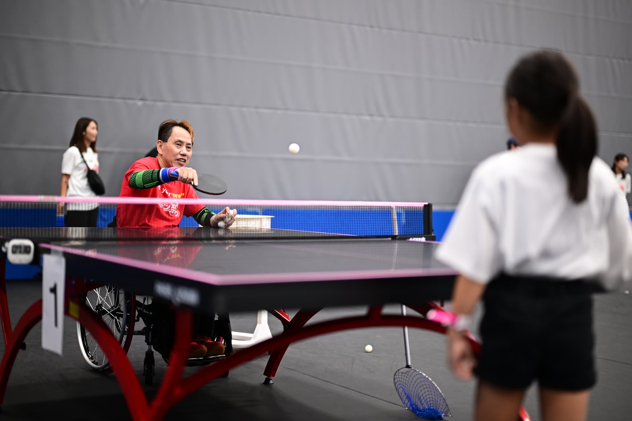 卓球体験教室で指導をする吉田新一さん（写真：アフロスポーツ）