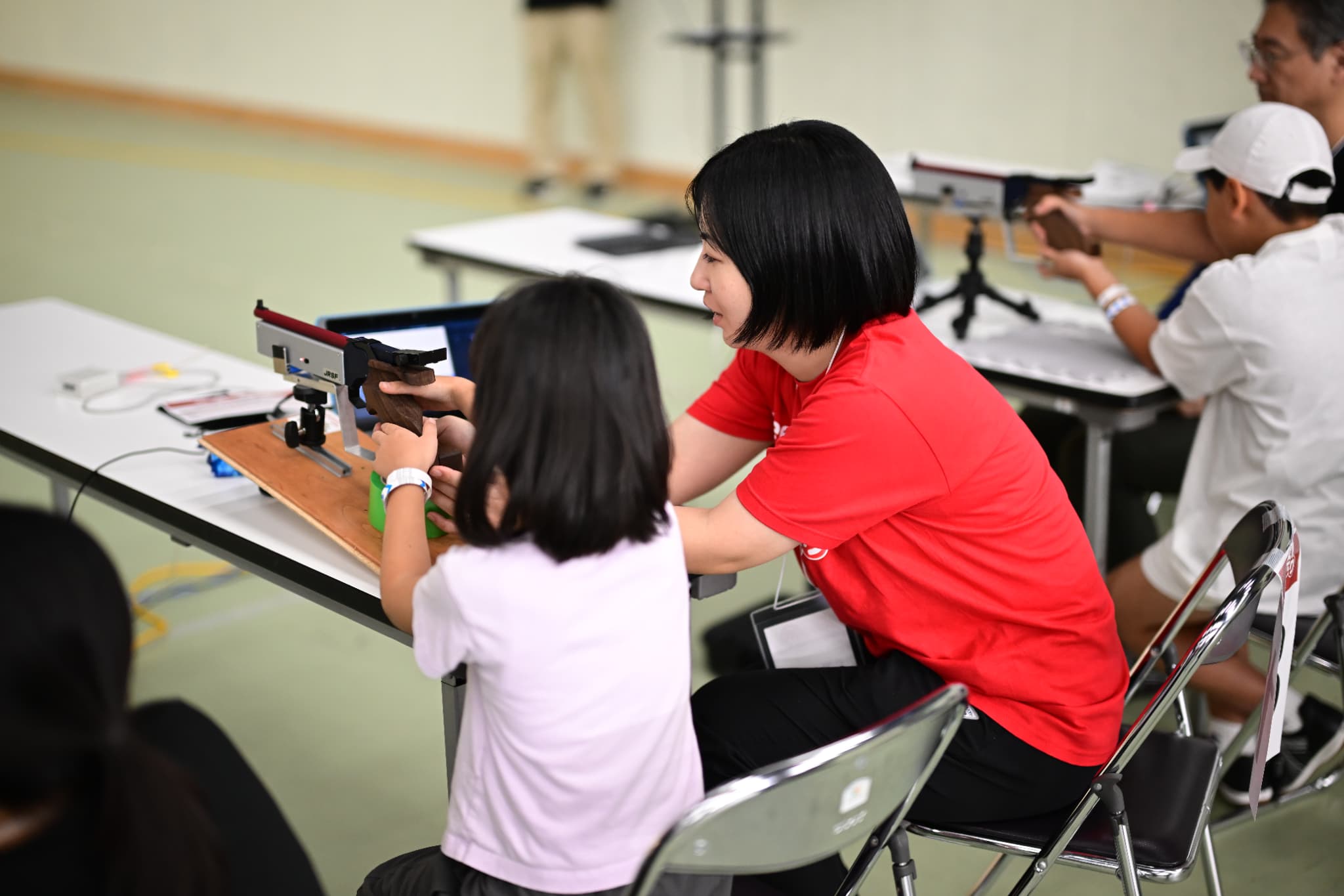 射撃体験教室で指導をする相澤ひかる選手（写真：アフロスポーツ）